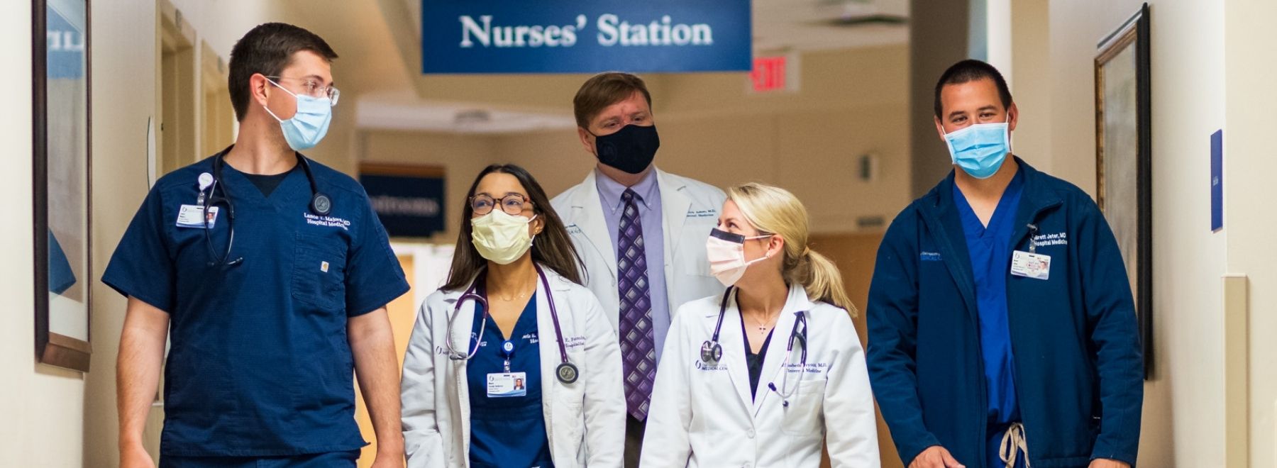 A group of hospital medicine physicians round on a unit